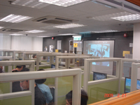 Trainees watching pilot DP next door on computer and projection screens